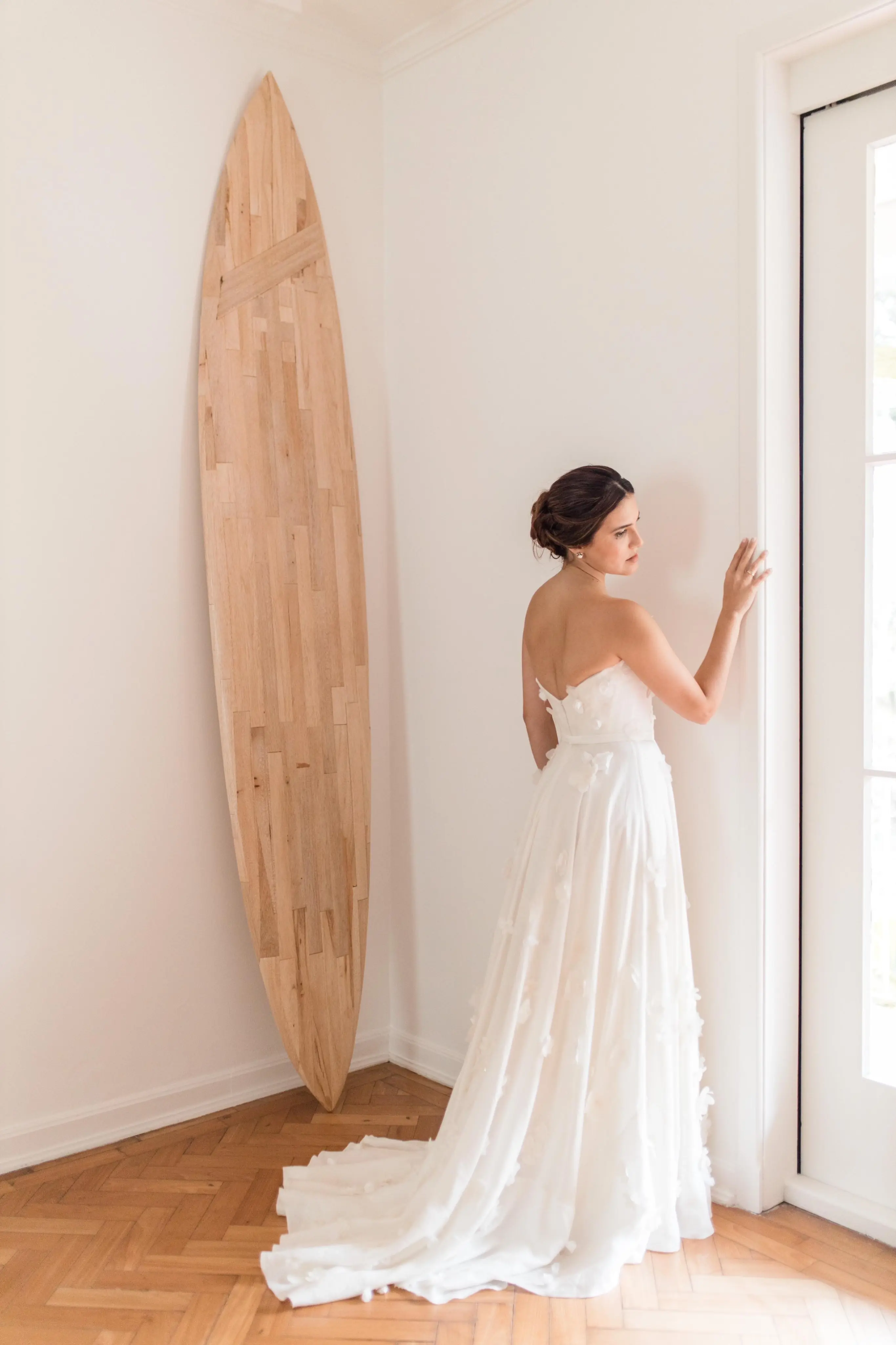 Mulher experimentando um vestido de noiva em frente a um espelho.